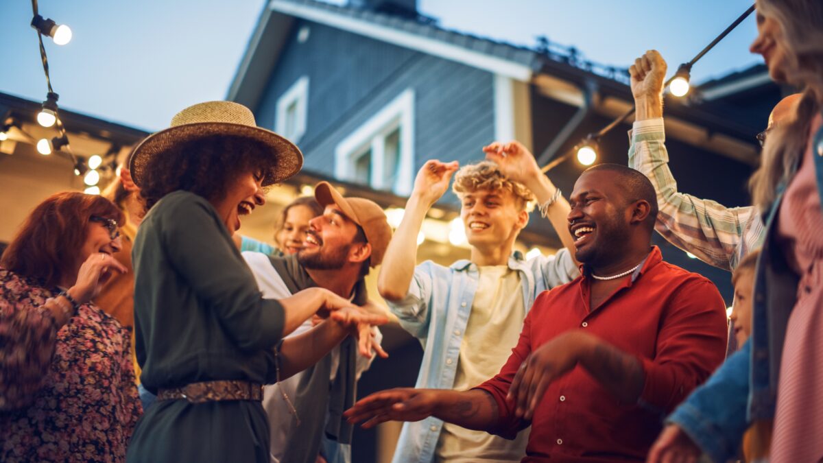 Friends and Family Dancing Together at an Outdoors Garden Party Celebration. Young and Senior People